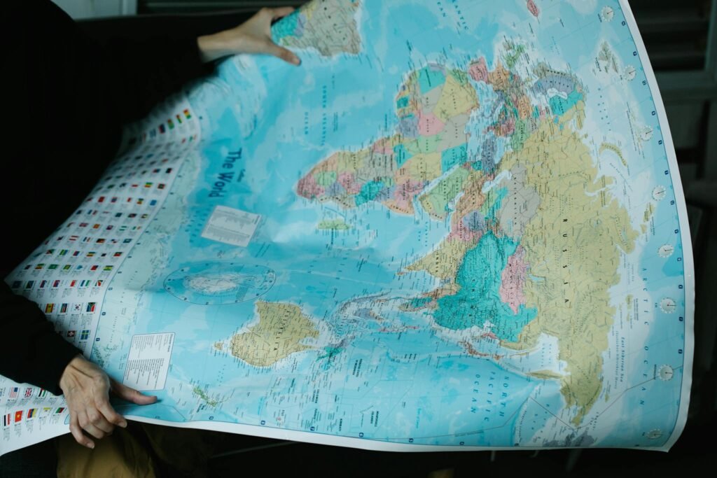 A person is holding a detailed political world map with vibrant colors.