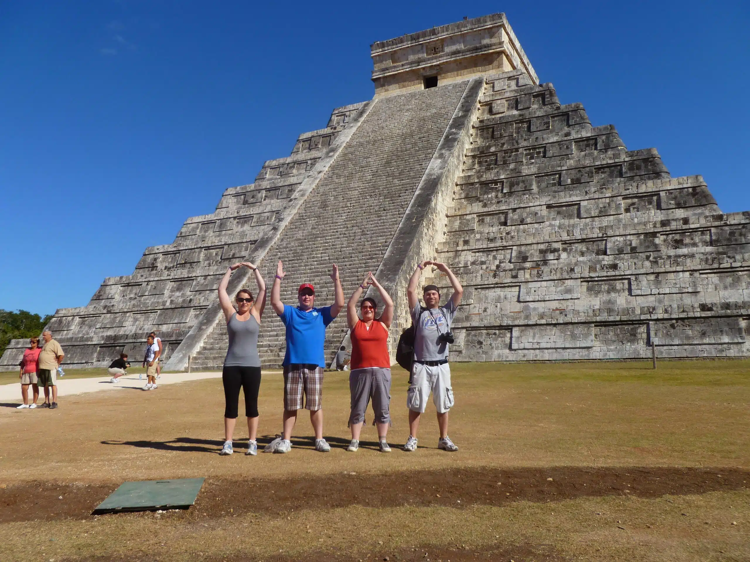 4 people in front of chichen itza doing O-H-I-O