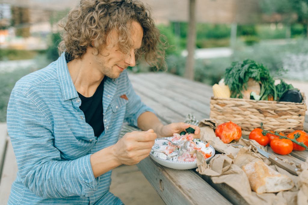 A man enjoying a healthy plant based meal with fresh vegetables while traveling abroad