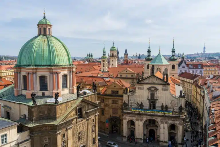 A breathtaking view of St. Francis of Assisi Church in Prague showcasing baroque architecture amidst cityscape.