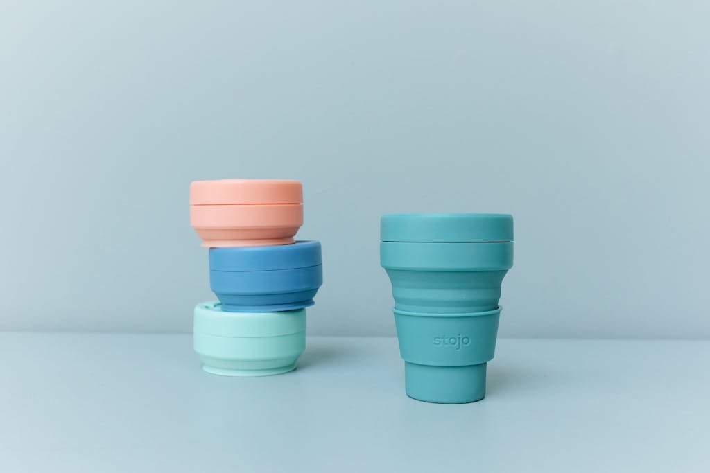Eco-conscious travel. Colorful reusable and collapsible cups promoting sustainability and zero waste living.