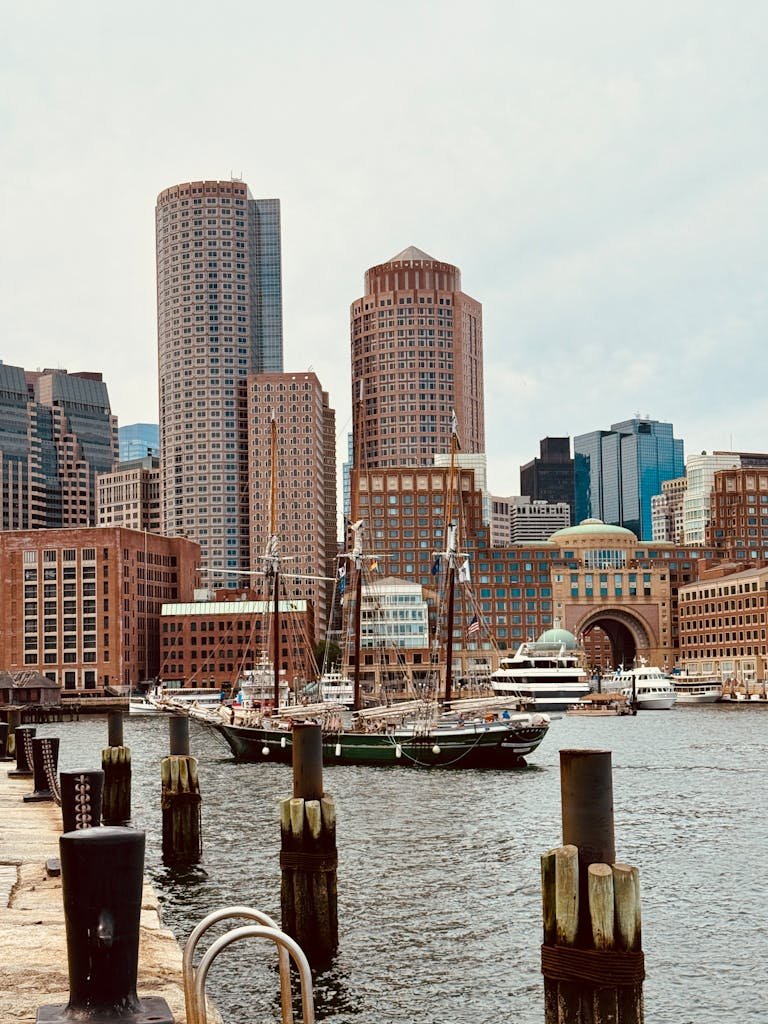 Boston skyline viewed from the harbor with fall foliage in the foreground — vegan road trip northeast USA