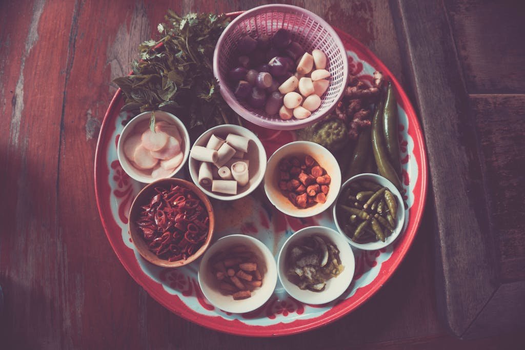 Colorful assortment of Thai cooking ingredients on a rustic wooden table.