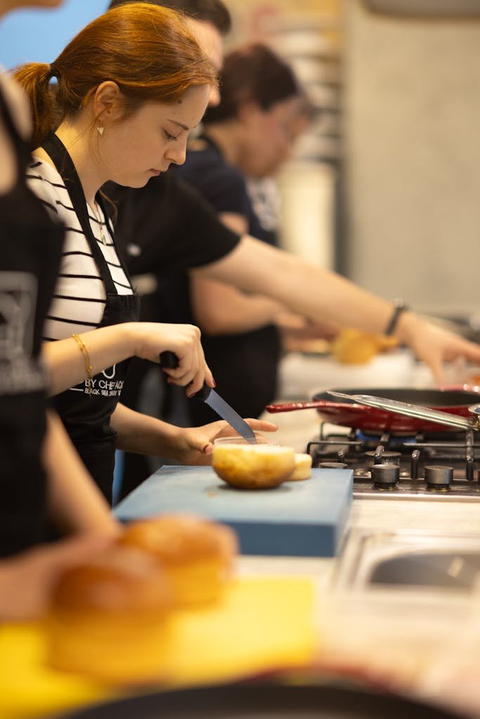 Focused woman slicing bread during a cooking class in Samsun, Türkiye.