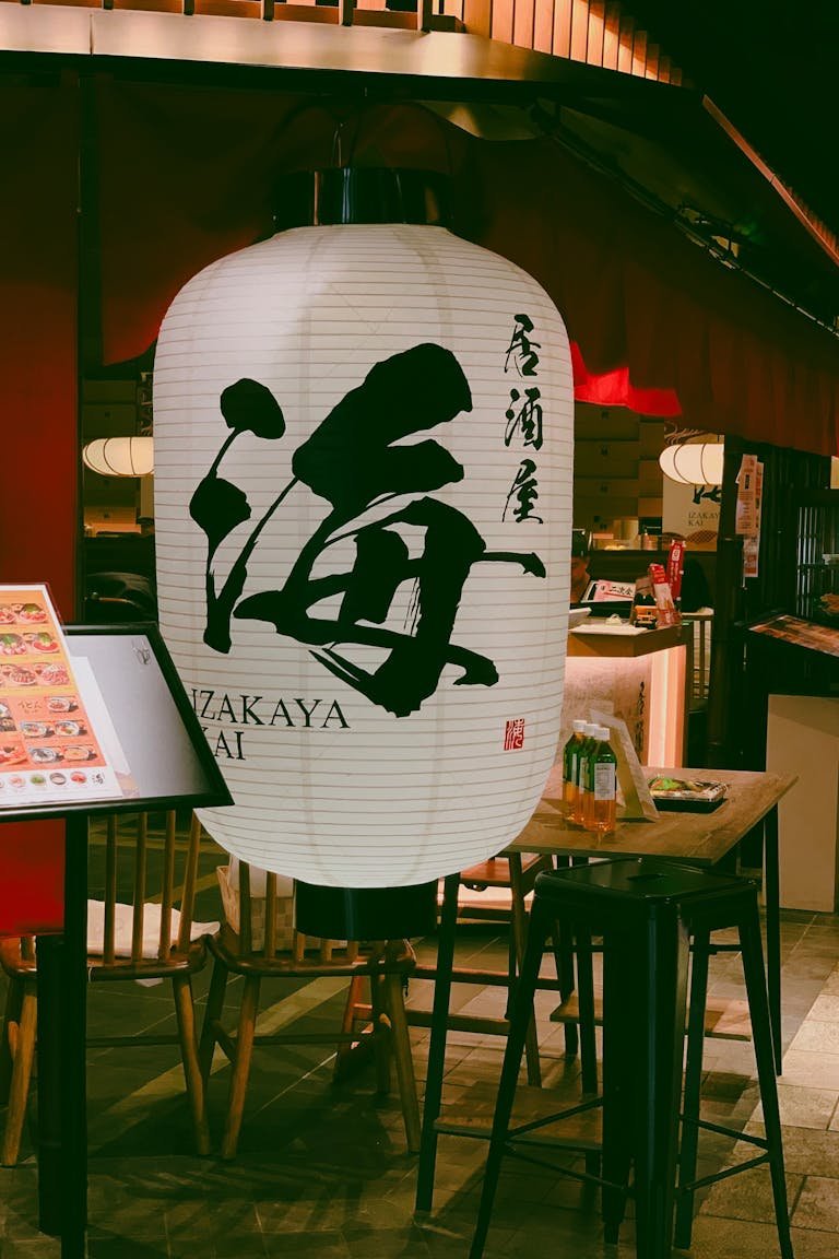 Illuminated lantern at a cozy Izakaya, offering an authentic Japanese dining experience.
