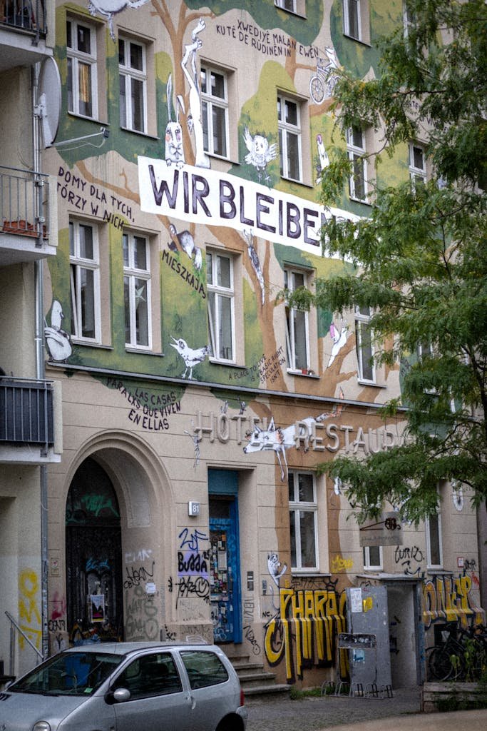 Vibrant mural with graffiti on a Berlin building facade, showcasing urban culture.