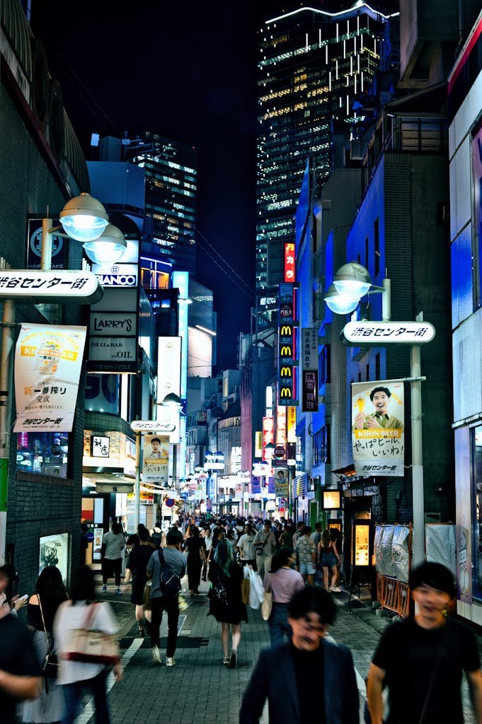 Vibrant night scene in Shibuya, Tokyo with bustling crowds and neon lights.