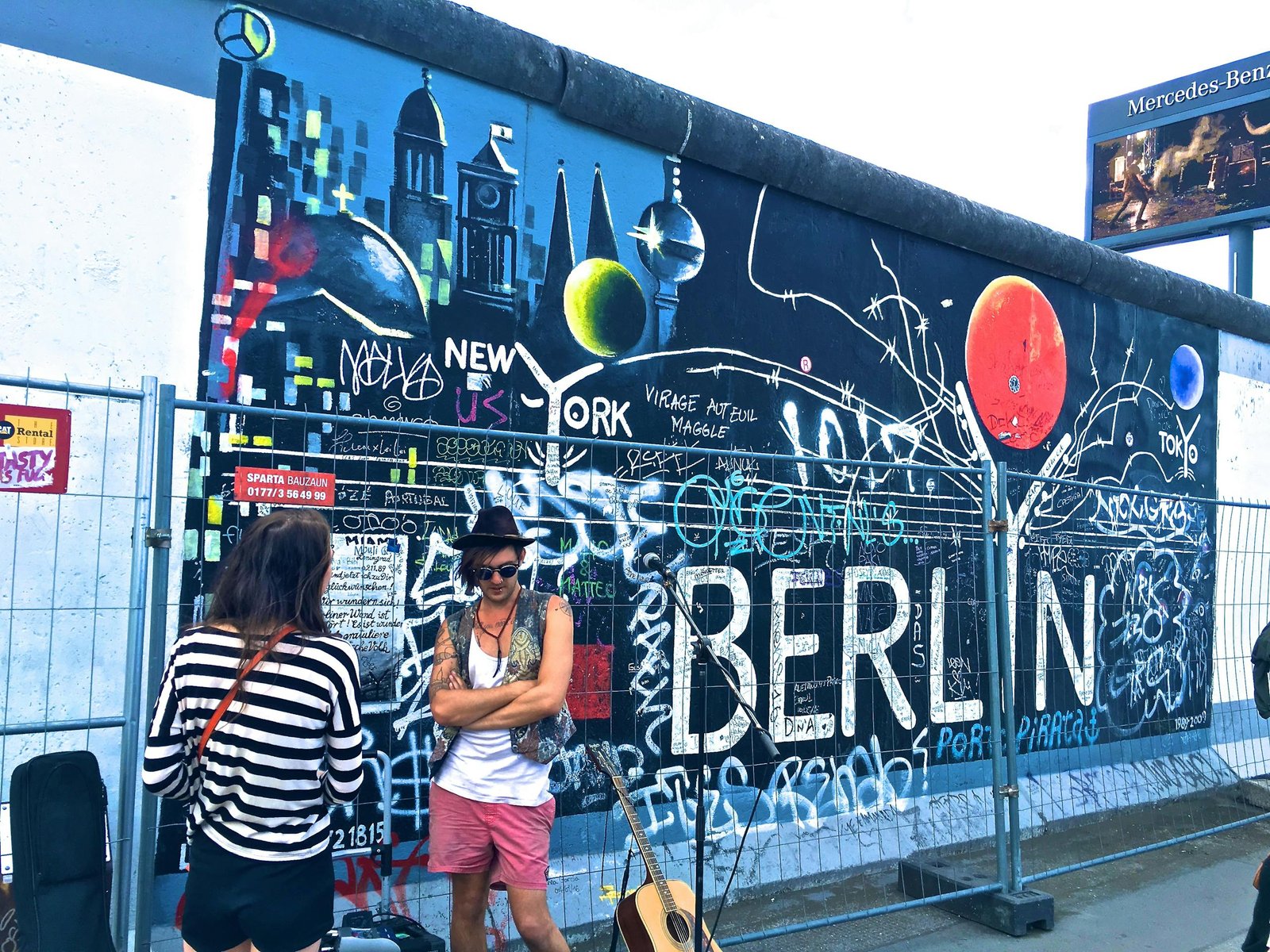Vibrant street art on the Berlin Wall, captured amidst a lively urban atmosphere.
