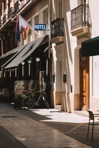 Quaint Valencia street scene featuring a hotel sign basking in warm sunlight, creating a welcoming atmosphere.