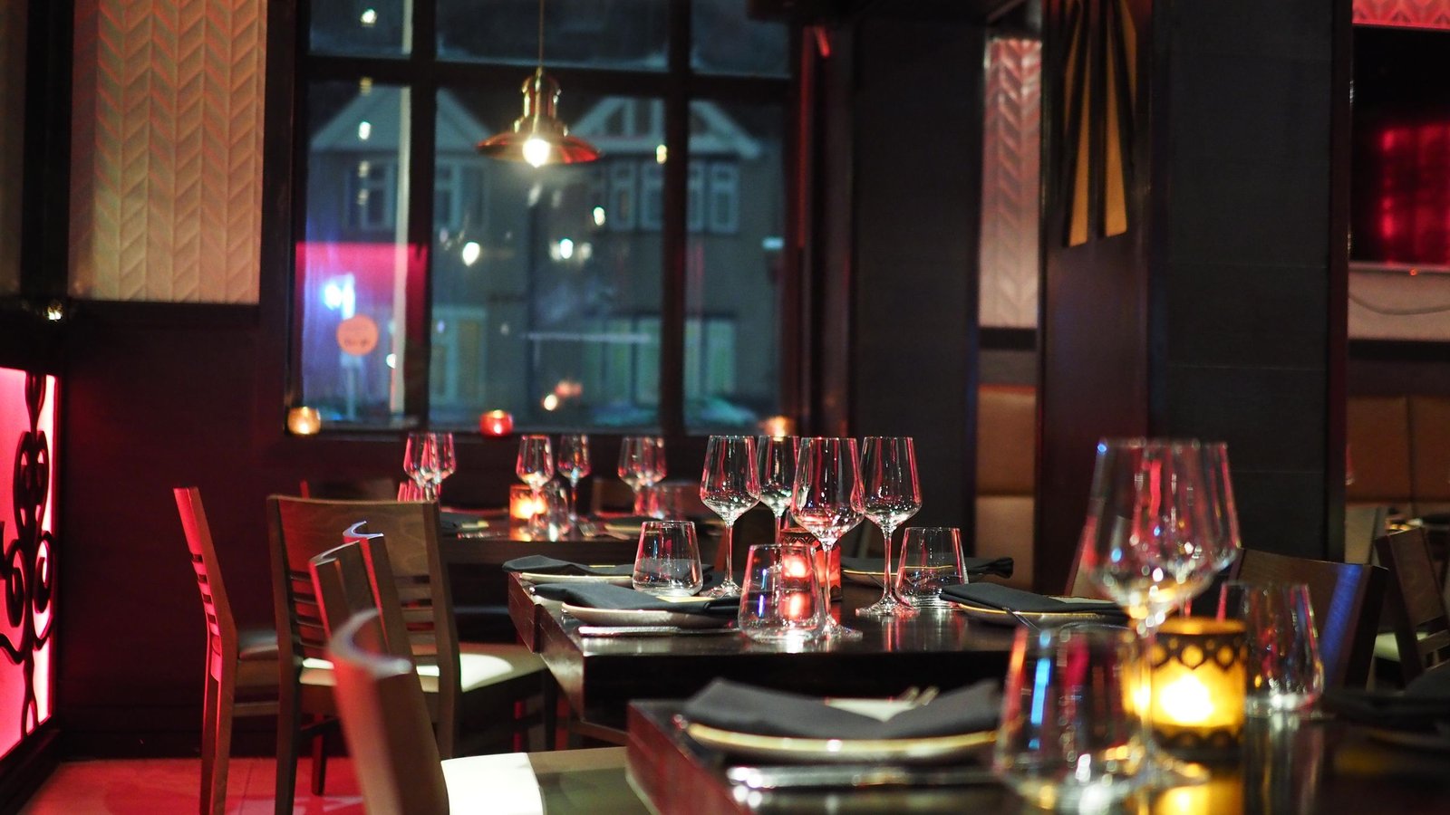 A sophisticated restaurant interior with elegant table setting and ambient candlelight, creating a cozy atmosphere.