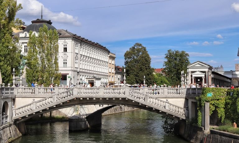 Sunny day at Ljubljana's iconic Triple Bridge with view for vegan travelers