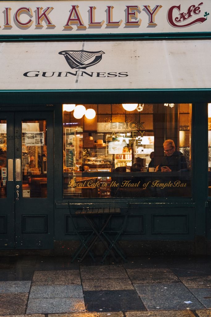 A warm view of a classic café in Temple Bar, Dublin, with a person inside.