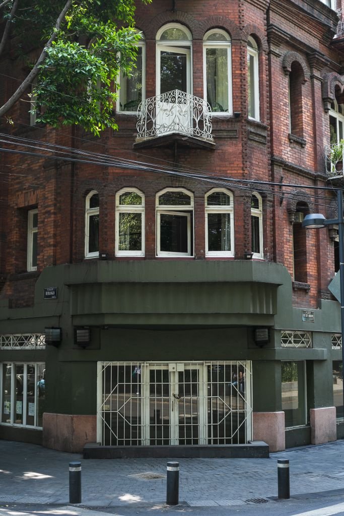 Charming brick building with ornate balconies in Mexico City's Roma neighborhood.