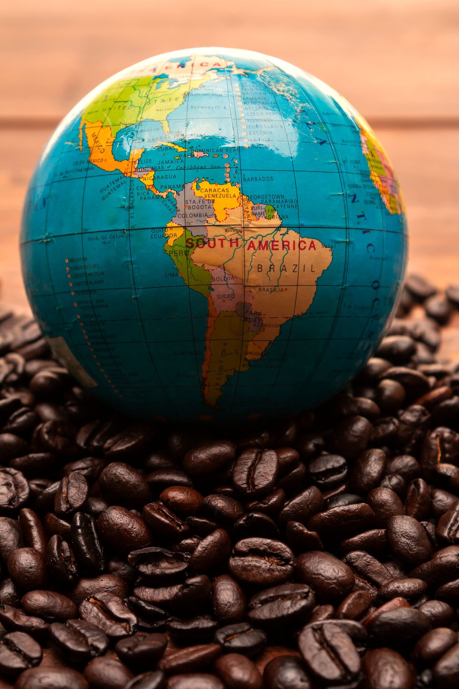 A globe on coffee beans highlighting South America's coffee origins.