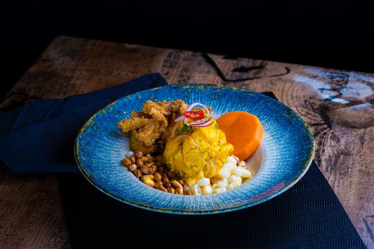 A vibrant plate featuring traditional Peruvian cuisine with vivid garnishes and textures.