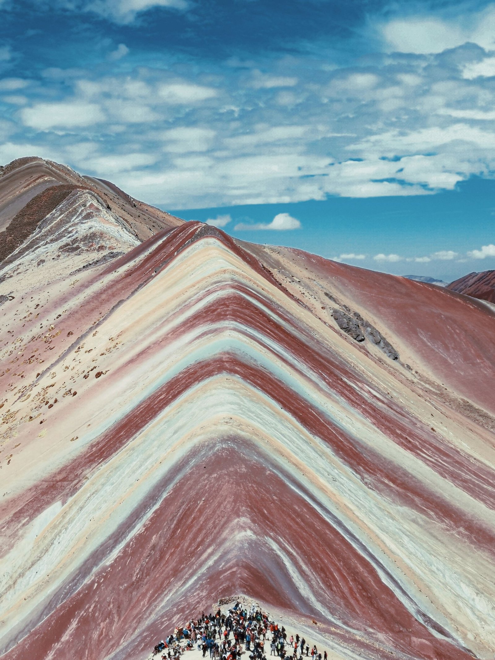 Breathtaking aerial view of the colorful Rainbow Mountain in Peru under a clear blue sky.