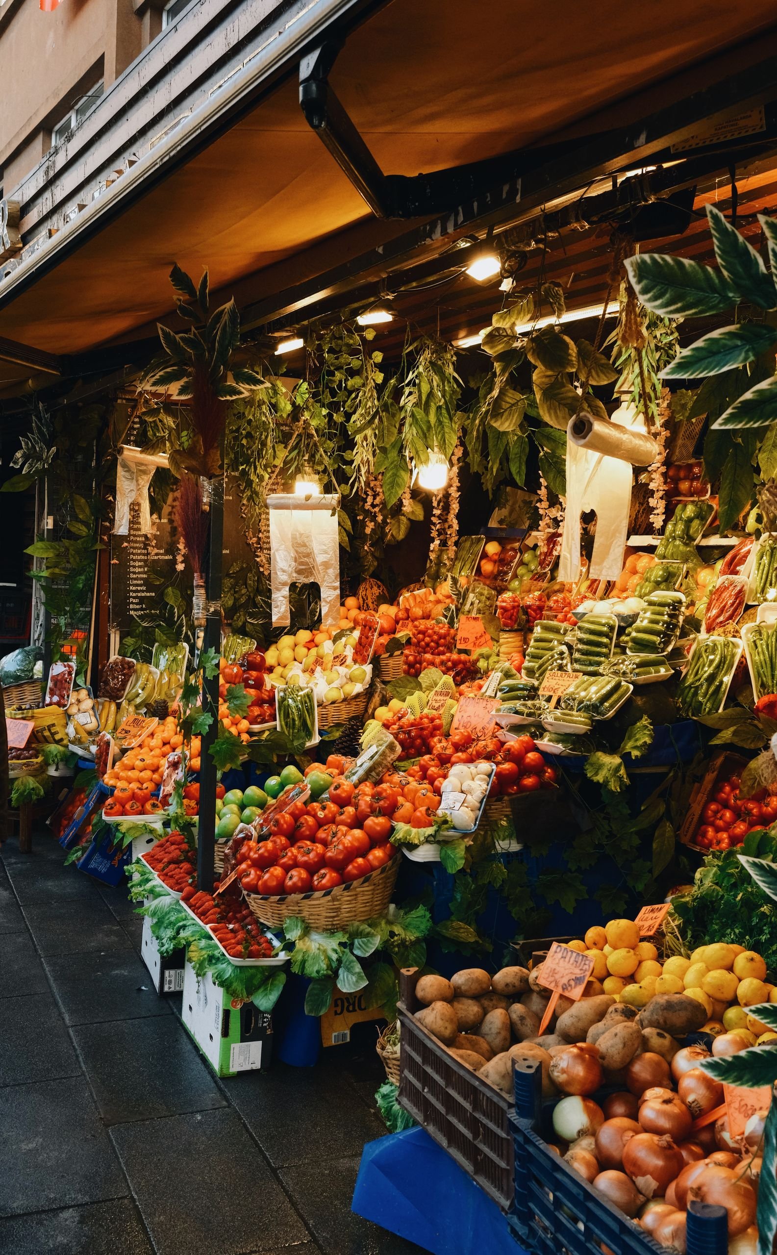 Lush display of fresh fruits and vegetables at a bustling farmers market stand.