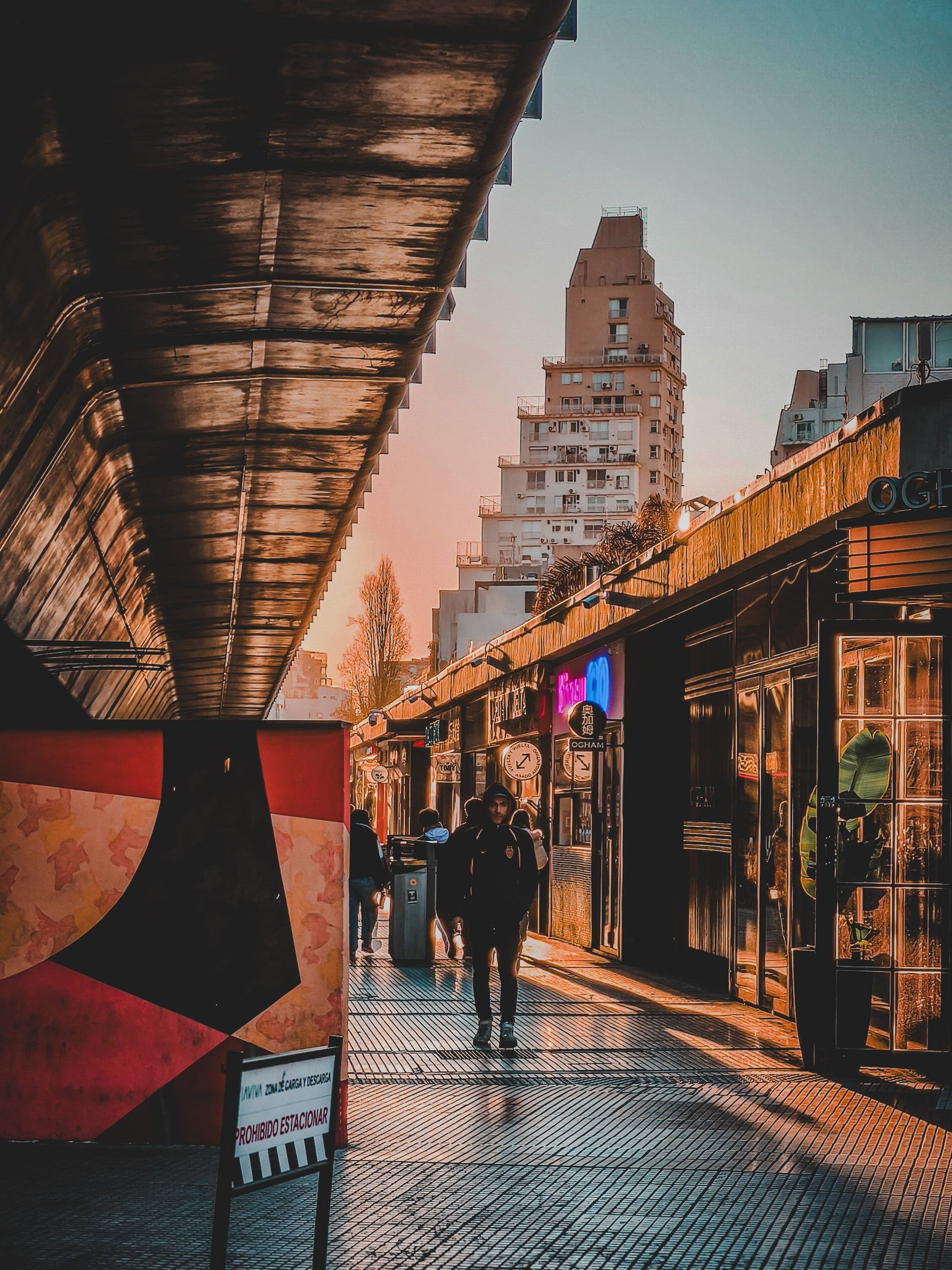 Vegan travel in Argentina. Vibrant sunset urban street view in Buenos Aires with people walking and colorful lights.